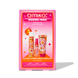 A product image of Amika's 'Mission Minis' bestsellers set, featuring a pink and orange gradient box with retro-inspired designs. The front of the box displays the three products included: Perk Up Dry Shampoo, The Wizard Detangling Primer, and Soulfood Nourishing Mask. The products are arranged vertically on the box, with small icons and text indicating that these are travel-size items. The packaging is colorful and vibrant, with a playful, nostalgic design.