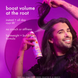 Man with long hair holding a can of hair product against a purple background. Text: "boost volume at the root. istant + all day root lift*. no crunch or stiffness. lightweight + buildable formula. *based on a visual expert grading evaluation of 31 subjects."