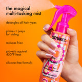 image of a hand holding the amika silicone-free detangling primer against an orange background. text: "this magical multi-tasking mist detangles all hair types, primes and preps for heat styling, reduces frizz, and protects against 450¬∫f heat, silicone-free formula."