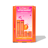 A product image of Amika's 'Next-Level Nourishment' signature routine set in bright orange and pink packaging. The box displays three full-size products: Normcore Signature Shampoo, Normcore Signature Conditioner, and Soulfood Nourishing Mask. The design is vibrant with a retro-inspired theme.