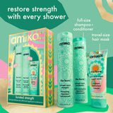 Amika 'The Kure' hair care set featuring a full-size shampoo and conditioner bottle, a travel-size hair mask tube, and the matching gift box, displayed alongside promotional text on a colorful teal, pink, and beige background.
