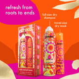 Amika Perk Up dry shampoo set featuring a full-size dry shampoo canister, a travel-size dry mask canister, and its retail box, all decorated with a vibrant orange, pink, and yellow retro floral pattern. The products are displayed against a bright orange and magenta graphic background with text overlays.