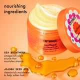 a jar of amika soulfood mask sits on an orange surface with sea bukthorn berries and jojoba seed oil. text: "nourishing ingredients. sea buckthorn is an omega-rich plant source that nourishes strands. jojoba seed oil is a vitamin-rich moisturizer that helps soften hair. "