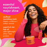 A smiling woman with long curly dark hair poses with two amika haircare products against a bright orange and pink graphic background. Text on the left reads 'essential nourishment, major shine' and lists soulfood nourishing mask and superfruit star hair oil benefits.