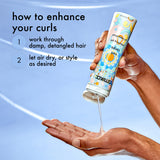 Hair product being applied to a hand with text on how to use it, against a light blue background.