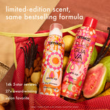Two bottles of amika dry shampoo with guava granita flavor on a red mesh bag with fruits.
