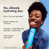 Person holding a blue bottle with text about hair care products on a light background