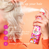 Person using a bottle of 'Perk Up Ultra' oil control dry shampoo on their hair with instructions displayed.