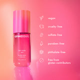 a bottle of amika:aura hair + body mist against a pink background. amika:aura is: vegan, cruelty-free, sulfate-free, paraben-free, phthalate-free and is free from gluten contributors. 