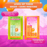 A promotional image comparing two Amika haircare sets: 'Play Your Strength' and 'Next-Level Nourishment.' The image is set against a vibrant background with floating orange balloons and a pink gradient landscape. At the top, a banner reads 'Level Up Their Wash + Care Routine' in an orange and white gradient. The 'Play Your Strength' set, on the left, is in green packaging and is labeled 'strengthen dry + damaged hair.' The 'Next-Level Nourishment' set, on the right, is in orange packaging and is labeled 'no