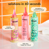 Three bottles of amika hair care products on a tiled bathroom floor.