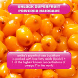 A close-up image of bright orange sea buckthorn berries with a glossy appearance. Overlaid on the image is a pink and white banner at the top that reads 'Unlock Superfruit Powered Haircare.' Below, another pink banner highlights the benefits of sea buckthorn, stating: 'Amika's superfruit sea buckthorn is packed with free fatty acids (lipids!) + 1 of the highest known concentrations of omega 7 in the world.' The text is in white, contrasting against the pink background.