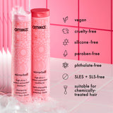 Amika mirrorball shampoo and conditioner bottles with product features on a pink background