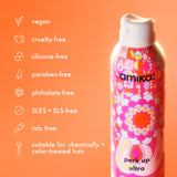 Amika hair product bottle with features listed on an orange background