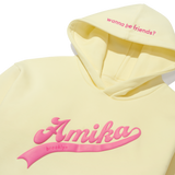 Yellow sweatshirt with pink text on the center and on the hoodie. text on the hoodie reads 'wanna be friends?'. text on the front of the sweatshirt reads ' amika brooklyn'. 