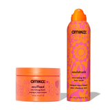 Two amika haircare products displayed side by side: on the left, an orange jar of Soulfood Nourishing Mask with pink illustrated patterns; on the right, an orange and pink aerosol can of Soulstruck Nourishing Dry Hair Mask with bold floral-inspired graphics.