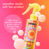 Amika frizz-me-noil hair product with colorful packaging on a pink and orange gradient background