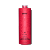 A tall, cylindrical bottle of Amika 'The Protector' color protect and strengthen shampoo, featuring a vibrant pink-red body with a subtle floral pattern and black text, set against a plain white background.