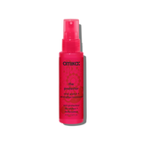A bottle of Amika 'The Protector' color protect hair spray, featuring a translucent hot pink bottle and cap with black text, set against a plain white background.